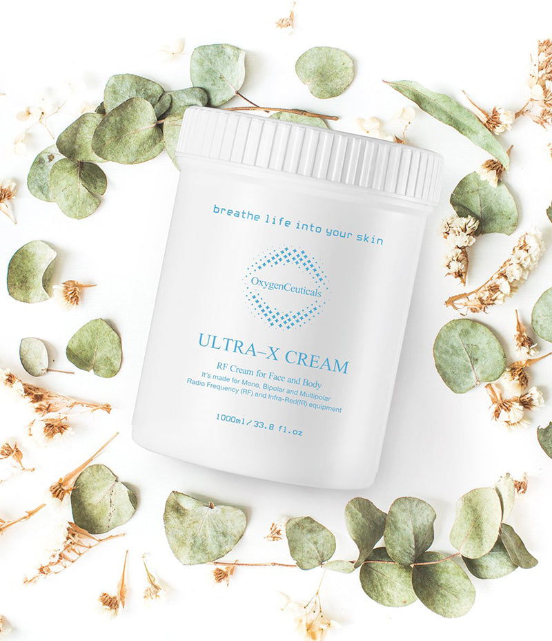 Ultra-X Cream 罐斜放在白色背景上，四周摆放着绿色叶子和干花