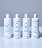 Four white bottles side by side labelled Oxygen Formula, Exfoliant Formula, Couperose Formula and Hydrating Formula, each 500ml 16.9 fl.oz