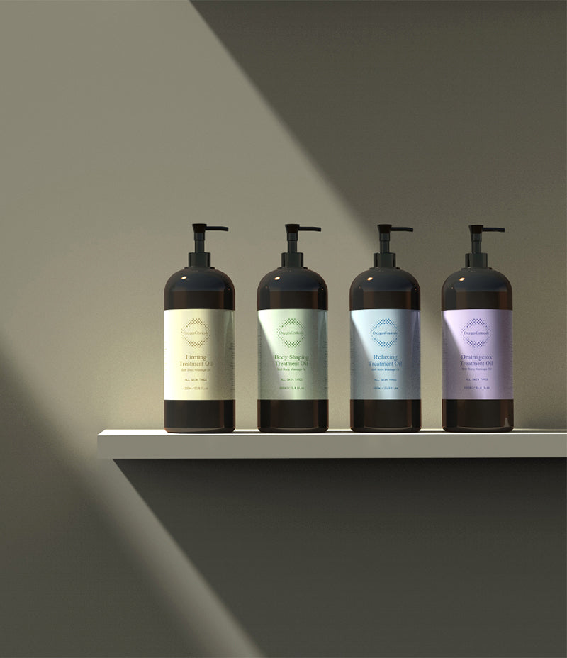 四支 Treatment Oil 泵头瓶放在白色架上，标签从左至右：Firming、Body Shaping、Relaxing、Drainagetox