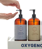 一只手按压 Relaxing Treatment Oil 泵头，另一只手在下方摊开；旁边是 Firming Treatment Oil 瓶