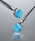 Close-up of two silver rollers with blue roller heads against a grey metallic background, OxygenCeuticals on the handles